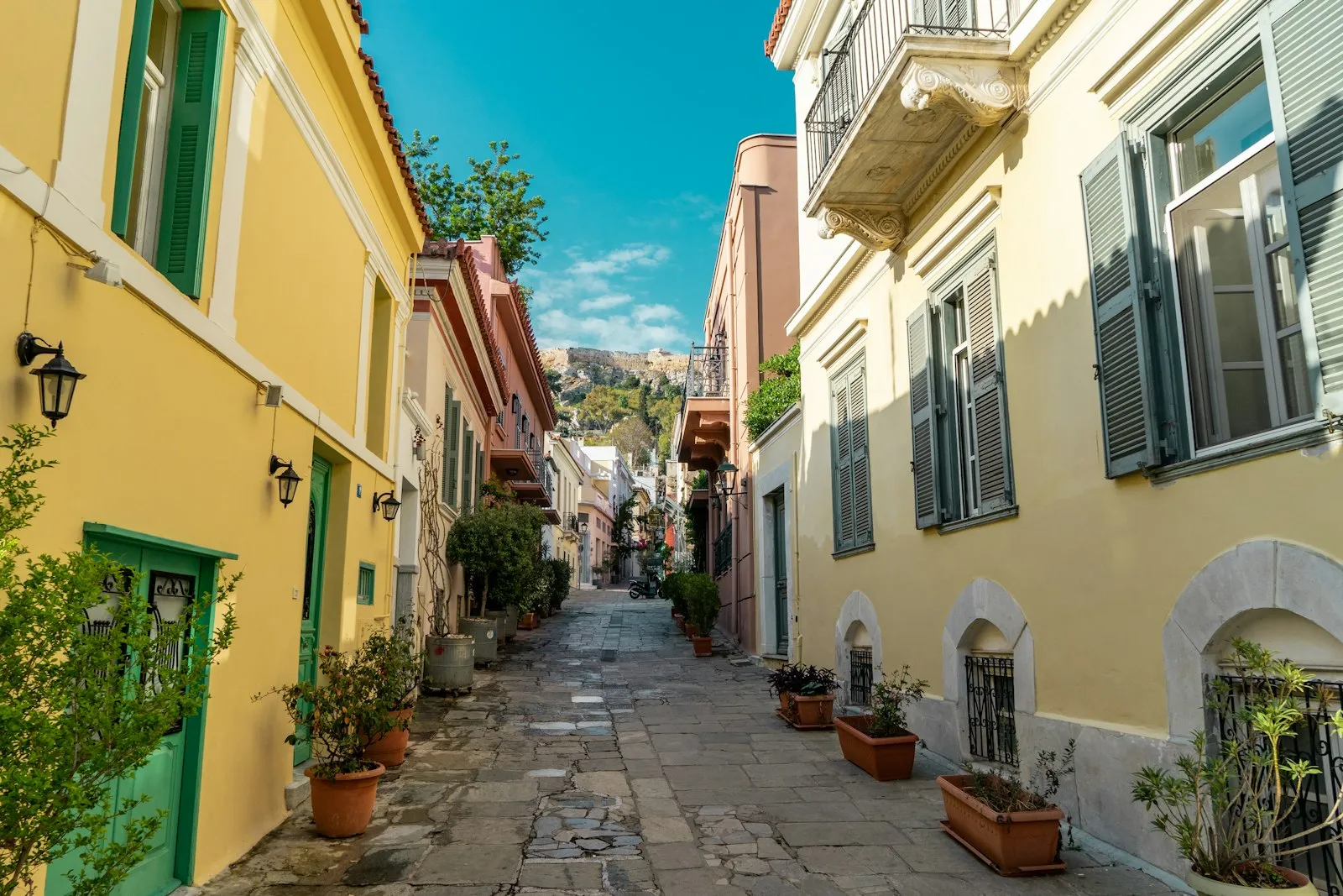 A cobbled street in Plaka with the Acropolis hill beyond